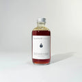 Glass bottle of BY VALENTI beautifully dark amber colored lavender face foaming cleanser with aluminum cap over white background