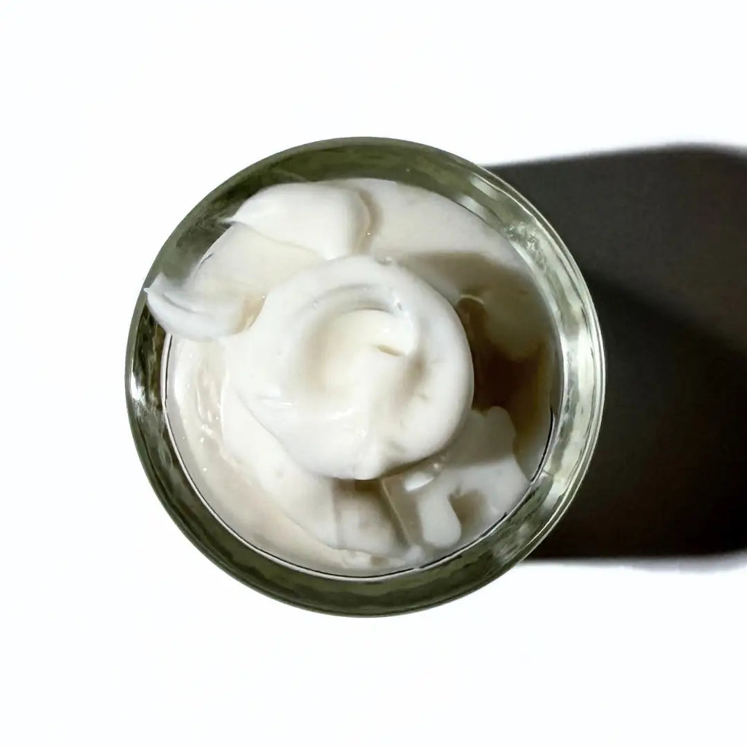 By Valenti Italian face lotion bottle from above with lotion dripping off glass bottle