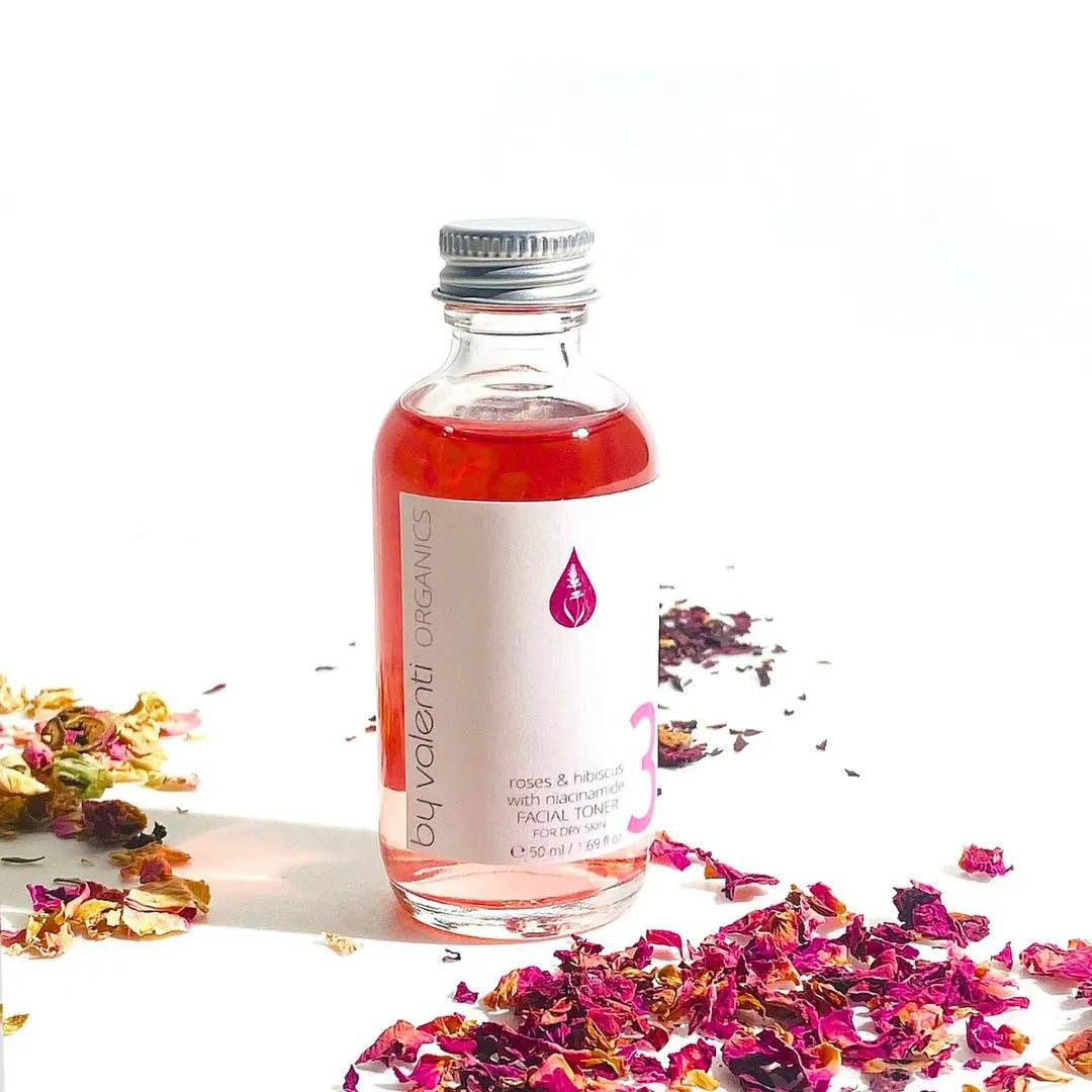 Bottle of By Valenti Organics skincare product with dried flowers on a white background 50 ml glass bottle