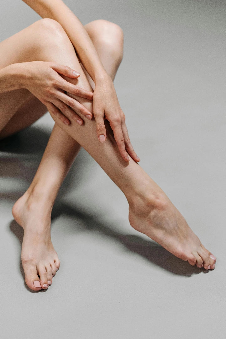 Close-up of a woman's legs and feet on a neutral background